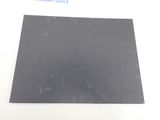 a close up of a piece of black paper on a white surface