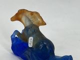 a glass figurine of a fish on a white surface