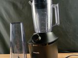un mixeur posé sur une table en bois, avec un autre mixeur à côté