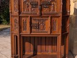 une armoire en bois dont la façade est ornée de sculptures