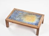 a small wooden table with a blue and yellow design on it