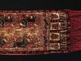 une photo d'un tapis rouge et noir orné d'oiseaux