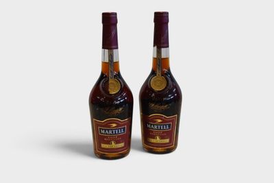 two bottles of brandy sitting next to each other on a white surface