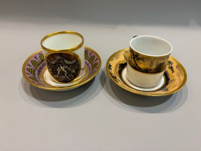 two cups and saucers are sitting side by side on a table