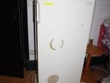 un réfrigérateur blanc avec un autocollant jaune sur la porte