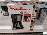 une boîte sur laquelle est posée une cafetière, exposée en vitrine