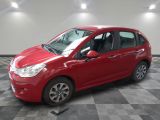 une voiture rouge est garée dans une pièce au sol en damier