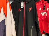 many jackets hanging on a rack in a store