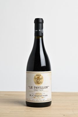 a bottle of wine sitting on top of a wooden table