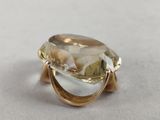 a close up of a ring with a faceted yellow topaz stone