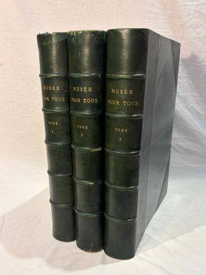 trois livres sont empilés sur une surface blanche