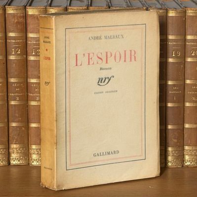 un livre posé sur une étagère, devant une pile de livres