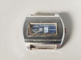 une montre argentée et bleue posée sur une surface blanche