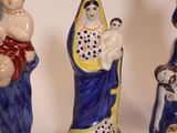 four ceramic figurines of a woman, a man and a child