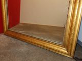 a mirror that is sitting on the floor next to a red wall