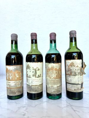 four bottles of wine are lined up on a table