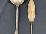 two spoons and a spoon rest next to each other on a table