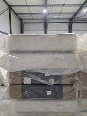 a large pile of mattresses in a warehouse