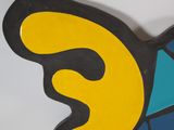 brightly colored butterfly shaped mirror on a white wall with blue and yellow accents