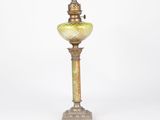 an old fashioned lamp with a green glass shade on it