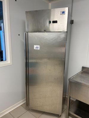 a stainless steel refrigerator in the corner of a kitchen