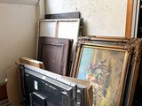 a pile of framed art on a pallet next to a window