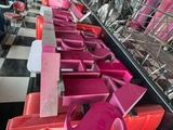 many pink chairs lined up in a row in a room