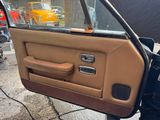 a car door with a brown leather interior and a tan door handle