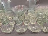 a lot of glasses and pitchers sitting on a table