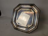 a silver plate with a mirror in it on a table