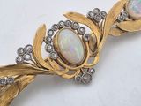 an image of a gold brooch with oplites and diamonds