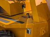 a large yellow machine that is parked in the dirt