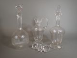 three glass vases and a glass bottle on a table