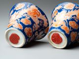 pair of blue and orange vases with dragon designs on them
