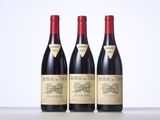 three bottles of red wine are lined up on a table