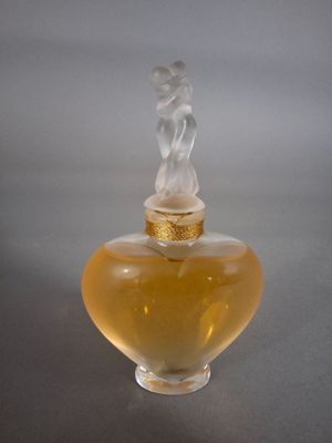 un flacon de parfum en verre avec un bouchon doré et un bouchon blanc