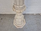 a white fire hydrant sitting on the sidewalk next to a wall