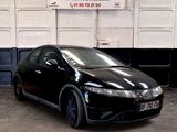 une photo d'une Honda Civic noire garée dans un garage