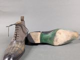 pair of men ' s shoes on a grey surface with a white background