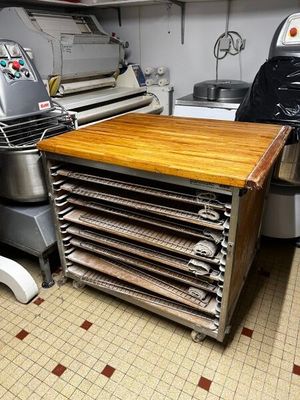 Plusieurs plateaux de nourriture sont posés sur une table en bois dans une cuisine