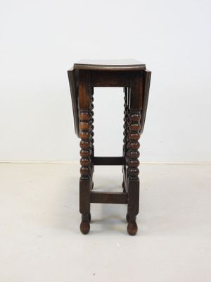 an old wooden stool with turned legs and a wooden seat