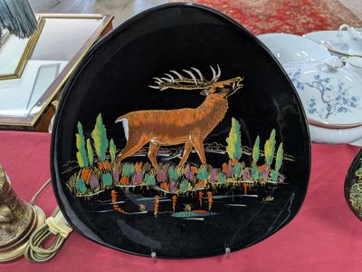 une assiette sur laquelle est représenté un cerf, posée sur une table