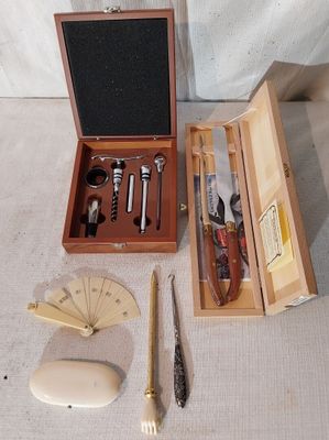 une boîte en bois contenant un couteau, une fourchette, un aiguiseur de couteaux et d'autres objets
