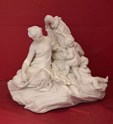 a white statue of a woman and two children on a rock