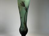 a glass vase with a bird on it sitting on a table