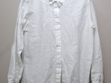 a white shirt hanging on a hanger against a wall