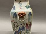 a vase with a handle that has a painting on it