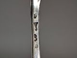 a spoon with a face on it sitting on a table