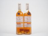 deux bouteilles de vin posées l'une à côté de l'autre sur une surface blanche
