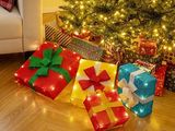 un sapin de Noël avec des cadeaux à ses pieds dans un salon